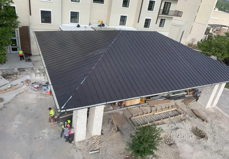 Metal roofing installation team working on a commercial building in Milton